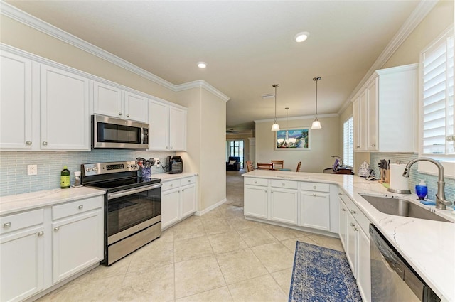 6547 Willowshire Way, Bradenton, FL 34212 - kitchen featuring stainless steel appliances, a sink, ornamental molding, tasteful backsplash, and white cabinetry