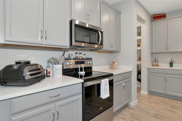 kitchen featuring gray cabinetry, stainless steel appliances, and light hardwood / wood-style floors