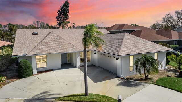2303 89th St NW, Bradenton, FL 34209 - ranch-style house with roof with shingles, stucco siding, concrete driveway, and a garage