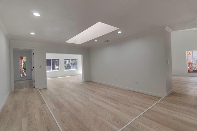 unfurnished living room featuring crown molding, a skylight, and light hardwood / wood-style flooring