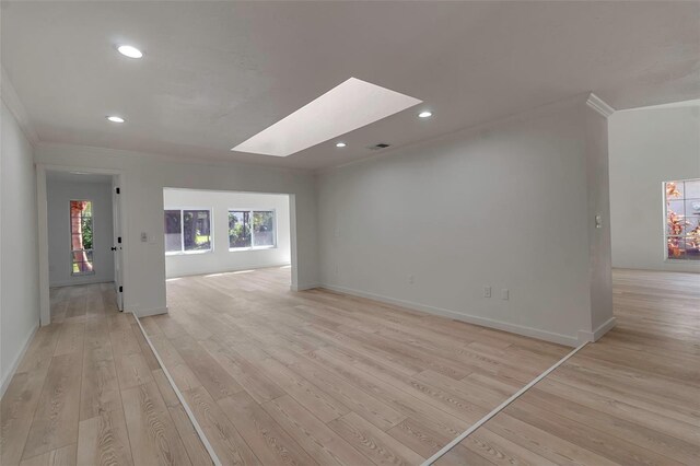 2303 89th St NW, Bradenton, FL 34209 - unfurnished living room featuring ornamental molding, light wood finished floors, a skylight, recessed lighting, and baseboards