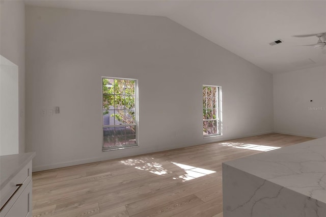 unfurnished living room featuring light wood-type flooring, high vaulted ceiling, plenty of natural light, and ceiling fan