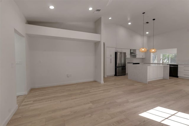 kitchen with stainless steel fridge, white cabinetry, light hardwood / wood-style flooring, wall chimney exhaust hood, and decorative light fixtures