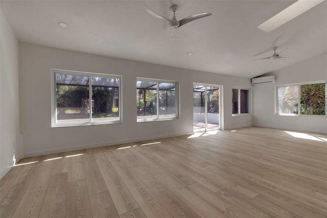 unfurnished living room featuring light hardwood / wood-style floors, a wall unit AC, and a wealth of natural light