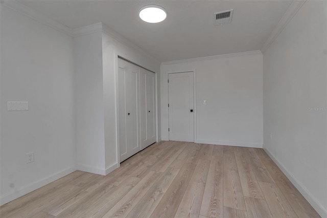 spare room featuring light hardwood / wood-style floors and ornamental molding