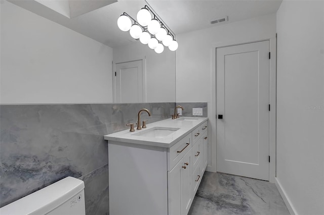2303 89th St NW, Bradenton, FL 34209 - bathroom featuring double vanity, marble look tile flooring, toilet, and tile walls