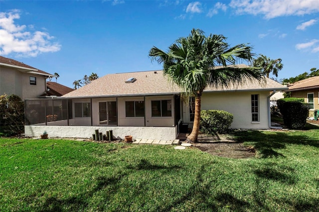 back of property with a yard and a sunroom