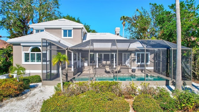 back of property with a patio area and glass enclosure