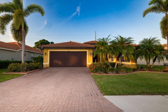 mediterranean / spanish house featuring a front yard and a garage