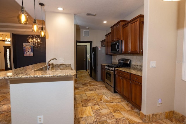 kitchen featuring stainless steel appliances, kitchen peninsula, sink, light stone countertops, and pendant lighting