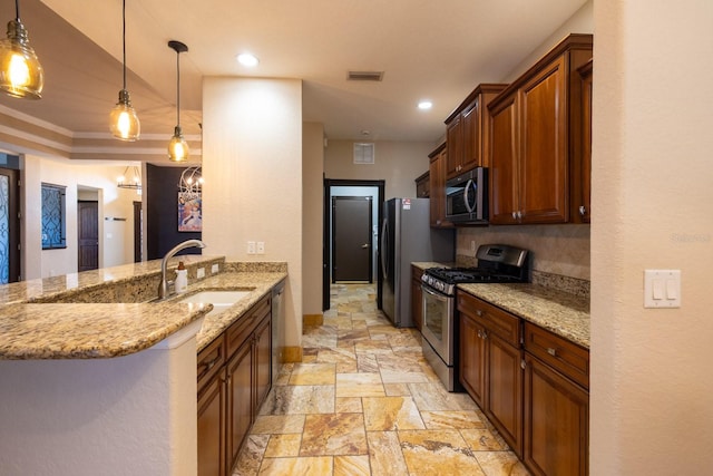 kitchen with stainless steel appliances, sink, light stone counters, kitchen peninsula, and pendant lighting