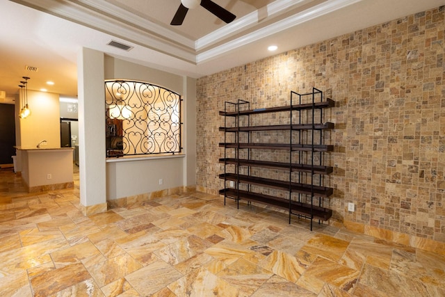 interior space with ceiling fan and ornamental molding