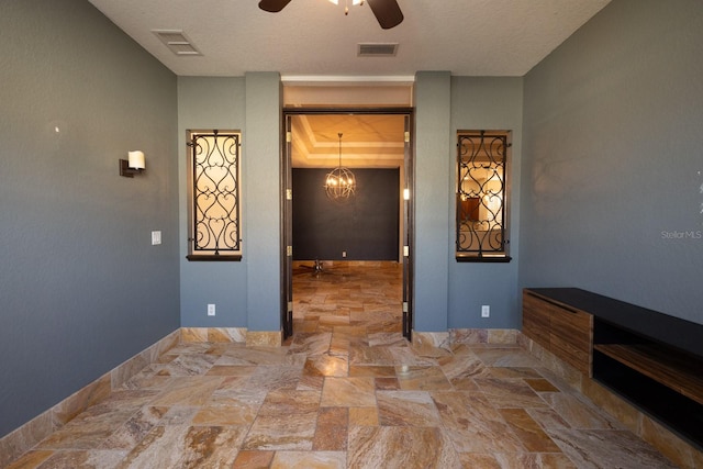 interior space featuring an inviting chandelier and a textured ceiling