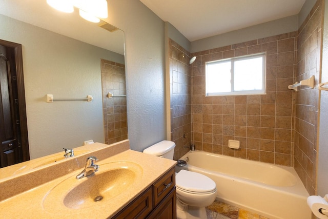 full bathroom featuring vanity, tiled shower / bath combo, and toilet