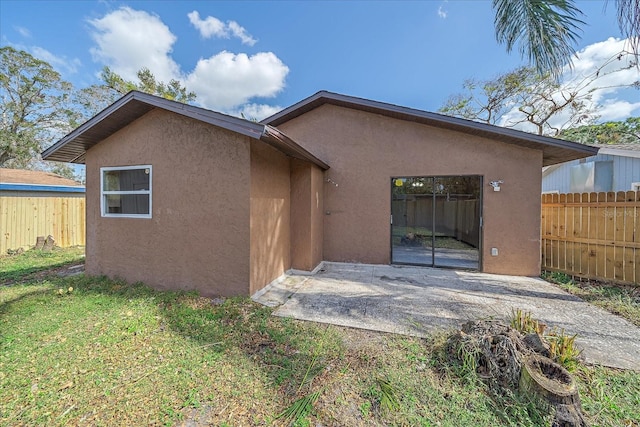 back of property with a yard and a patio area