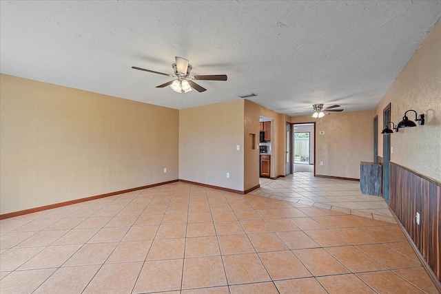 tiled spare room featuring a textured ceiling and ceiling fan