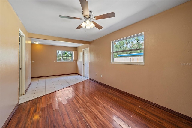 spare room featuring ceiling fan, a healthy amount of sunlight, and light wood-type flooring