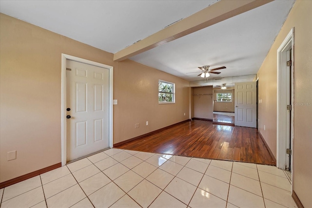 interior space with beamed ceiling, light hardwood / wood-style floors, and ceiling fan