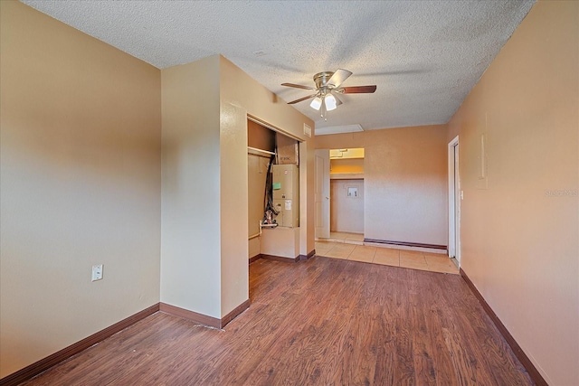 unfurnished room with light hardwood / wood-style flooring, a textured ceiling, and ceiling fan