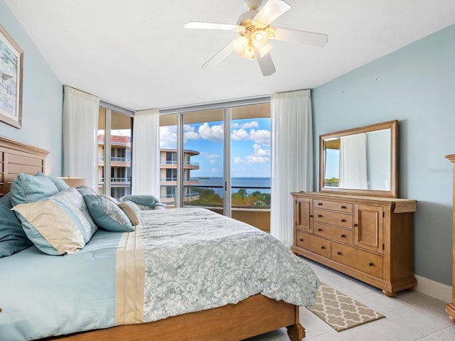 bedroom with a water view, ceiling fan, light tile patterned floors, and access to exterior