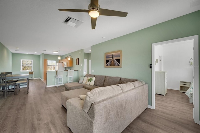 living room featuring light hardwood / wood-style flooring and ceiling fan