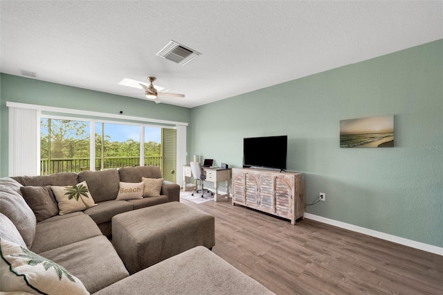 living room featuring hardwood / wood-style floors, a textured ceiling, and ceiling fan