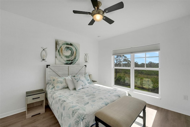 bedroom with dark hardwood / wood-style flooring and ceiling fan