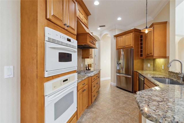 kitchen with sink, appliances with stainless steel finishes, light stone countertops, light tile patterned floors, and backsplash