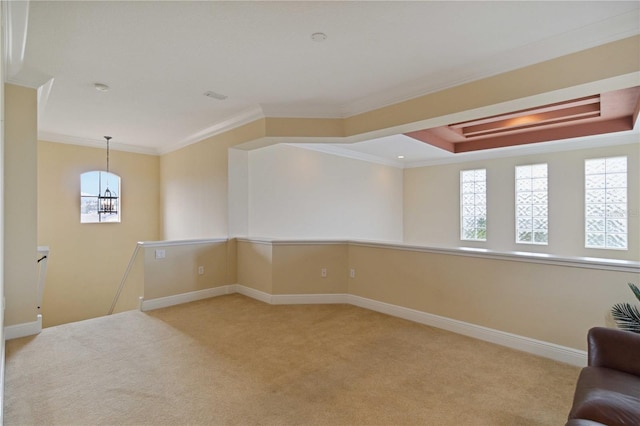 carpeted empty room featuring a raised ceiling and crown molding