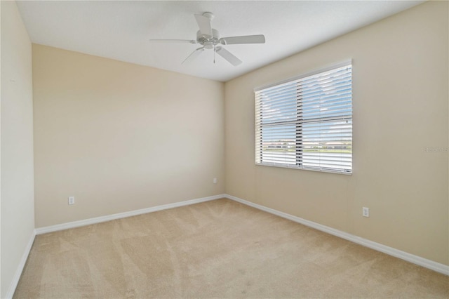 carpeted spare room featuring ceiling fan