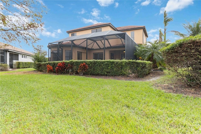 rear view of property featuring a lanai and a lawn