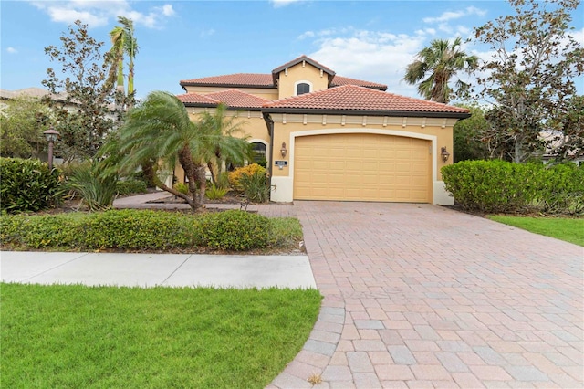 mediterranean / spanish-style house featuring a garage and a front yard