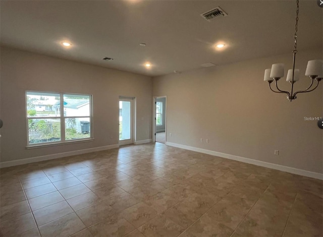 tiled spare room featuring a notable chandelier