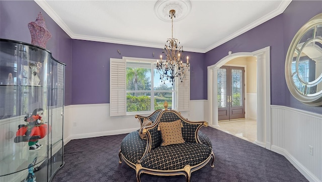 sitting room featuring ornamental molding, a chandelier, a wealth of natural light, and decorative columns