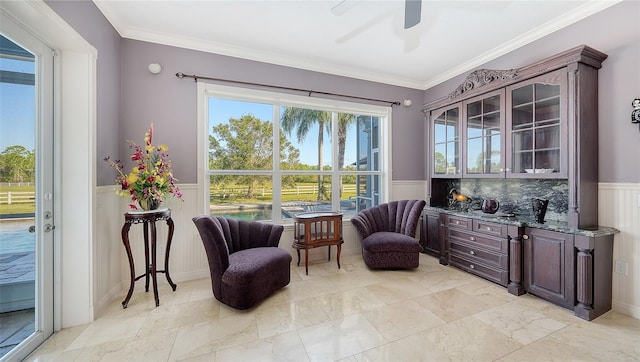 living area featuring crown molding and ceiling fan