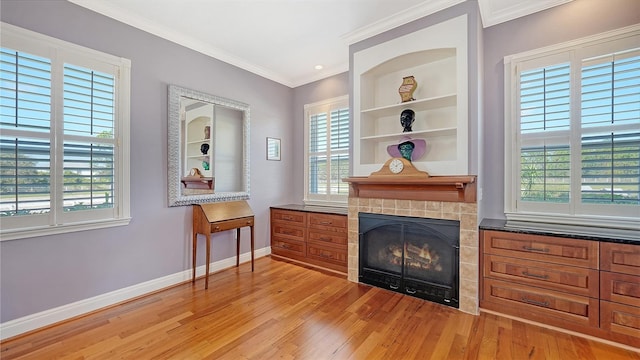 sitting room featuring light hardwood / wood-style floors, crown molding, and a healthy amount of sunlight