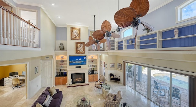 living room featuring a towering ceiling, crown molding, and ceiling fan