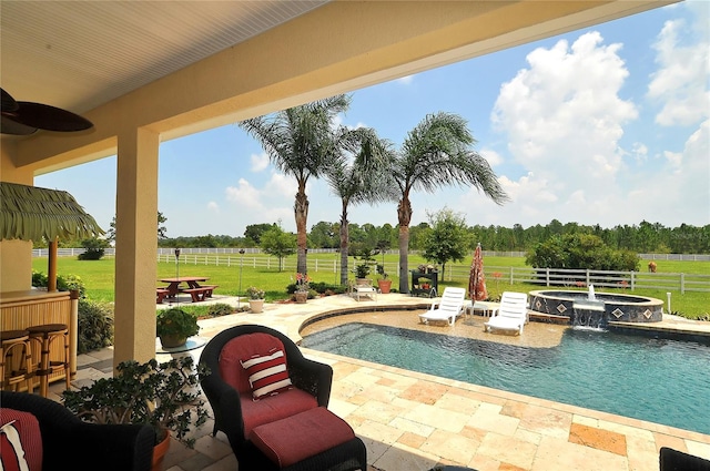 view of swimming pool with a patio, a yard, an in ground hot tub, and a rural view