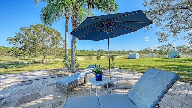 view of patio / terrace featuring a shed and a rural view