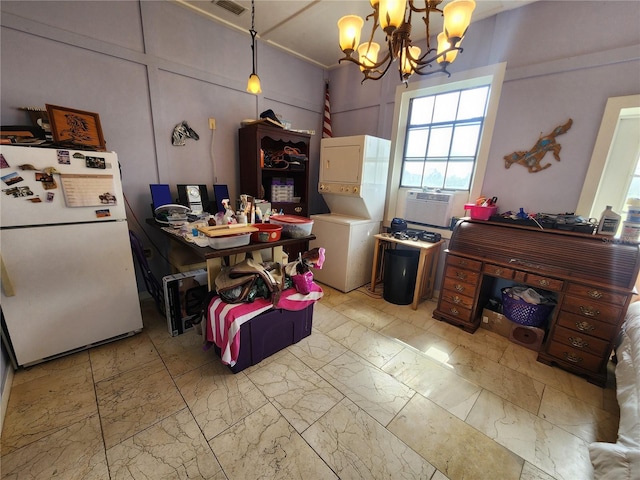 kitchen with stacked washer / dryer, cooling unit, hanging light fixtures, white fridge, and an inviting chandelier