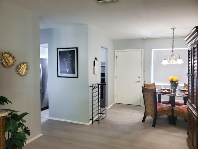 interior space with light hardwood / wood-style flooring and an inviting chandelier