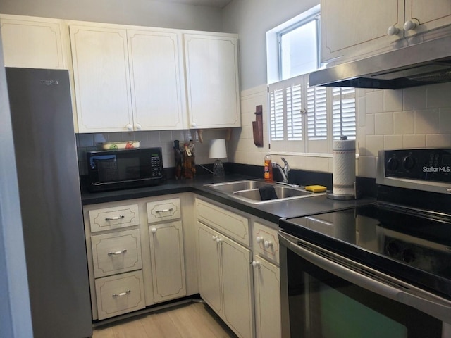 kitchen with sink, appliances with stainless steel finishes, white cabinets, and tasteful backsplash