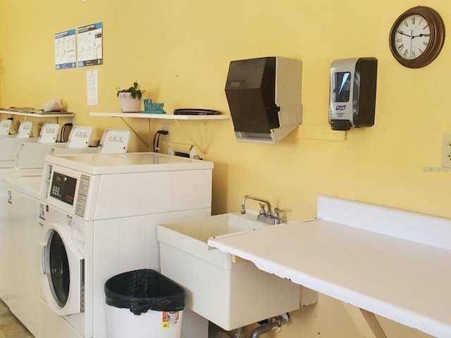 clothes washing area featuring sink and washer and dryer