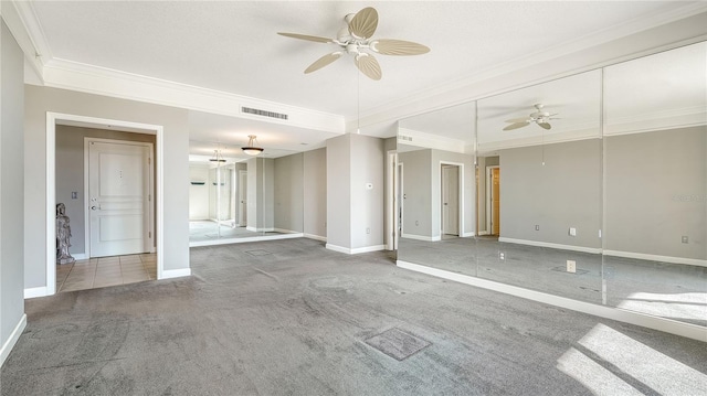 empty room with ornamental molding, carpet flooring, and ceiling fan