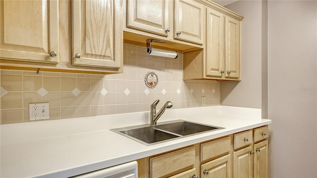 kitchen with light brown cabinetry, sink, and decorative backsplash