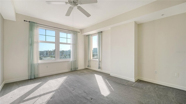 carpeted spare room featuring ceiling fan