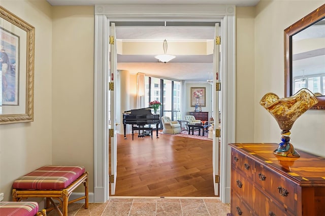 hallway featuring ornamental molding and light hardwood / wood-style floors