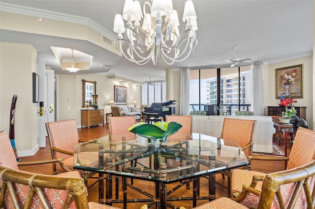 dining space with wood-type flooring, ceiling fan with notable chandelier, and crown molding