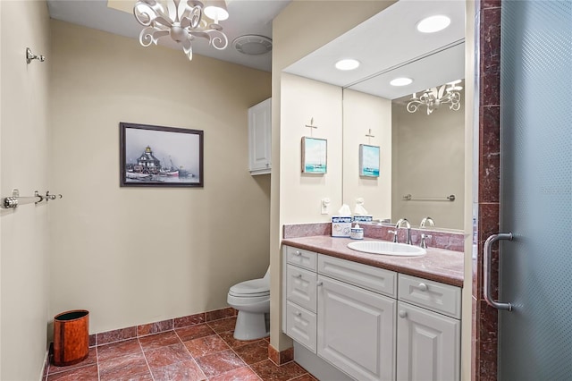 bathroom with an inviting chandelier, vanity, and toilet