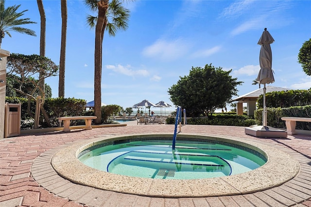 view of swimming pool featuring an in ground hot tub and a patio